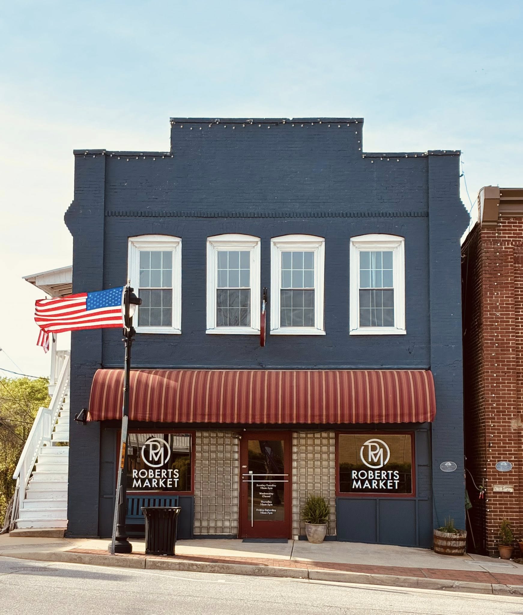 Roberts Market navy brick storefront with striped awning on Virginia Avenue