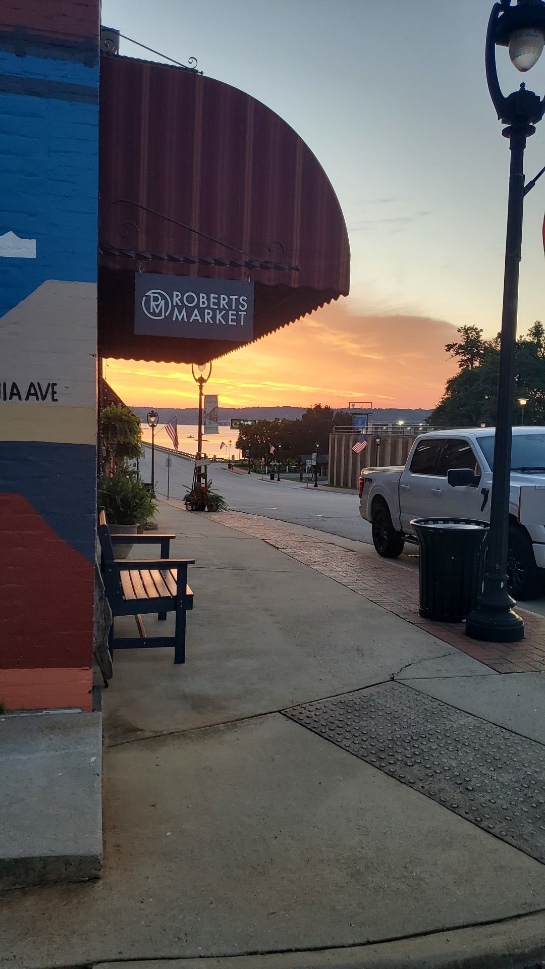 Roberts Market awning at dusk with the sun setting over the lake at the end of Virginia Avenue
